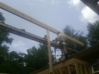 Carpenter setting a ridge beam over a new addition frame — Ice Dam Removal by Roofing Brothers in Nescopeck