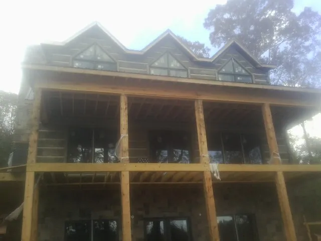 Dormers and porch framing on a large log home under construction — Roof Coating work by our crew in Nescopeck